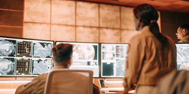 Security team in a control room using dashboards for proactive exposure management.
