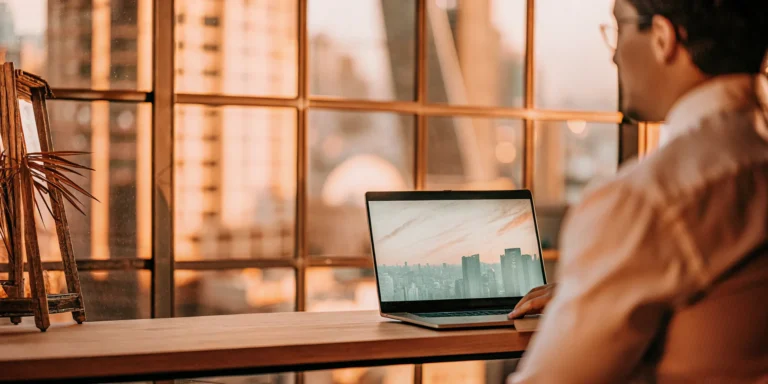 A man using a risk-based vulnerability management tool on a laptop to prioritize cyber risk.